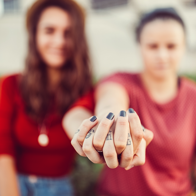 Images focuses on two hands clasped together.